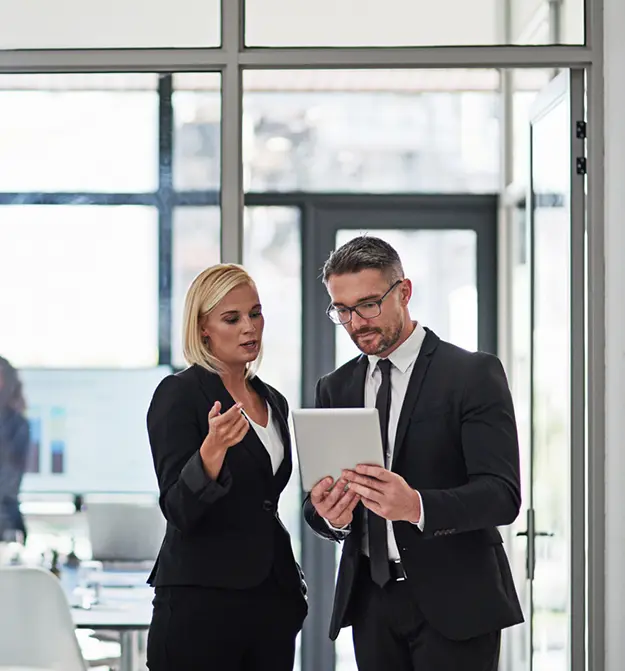 Two business people talking and looking at tablet, for Zetadocs ask us anything webinar thumbnail