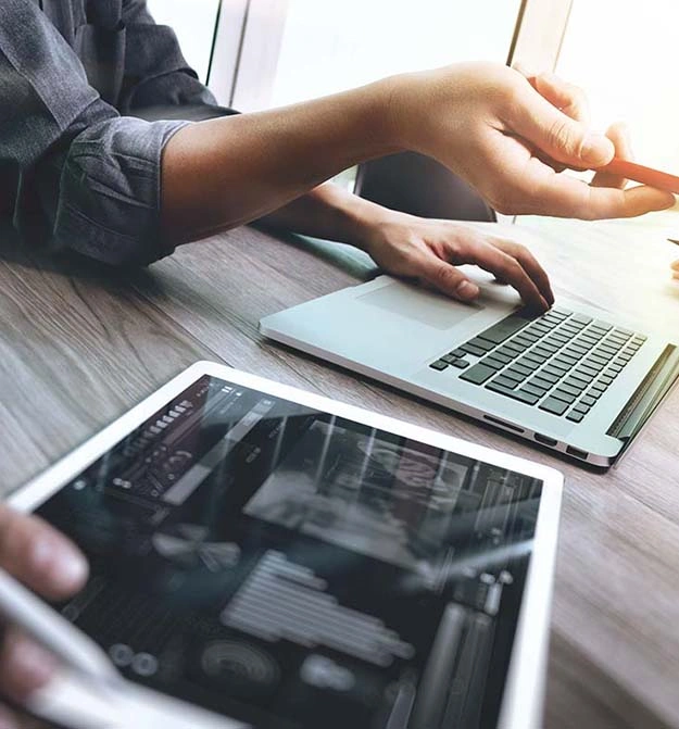 People on laptop and tablet, getting the benefits of Zetadocs document management software on Business Central