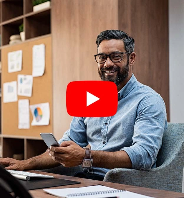 Male At Desk Smiling While Sending Remittance Advice To Suppliers using Zetadocs