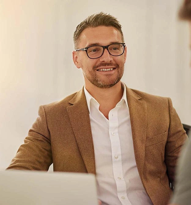 Male Sat At His Desk, Smiling After Receiving Quick Support For Business Central Document Management Software Zetadocs