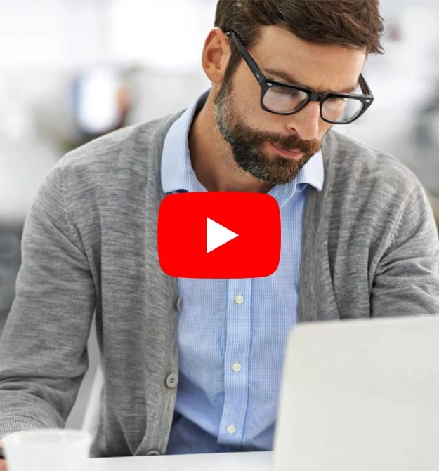 Male Sat At His Desk, Smiling After Using Business Central Expense Management Software Zetadocs Expenses